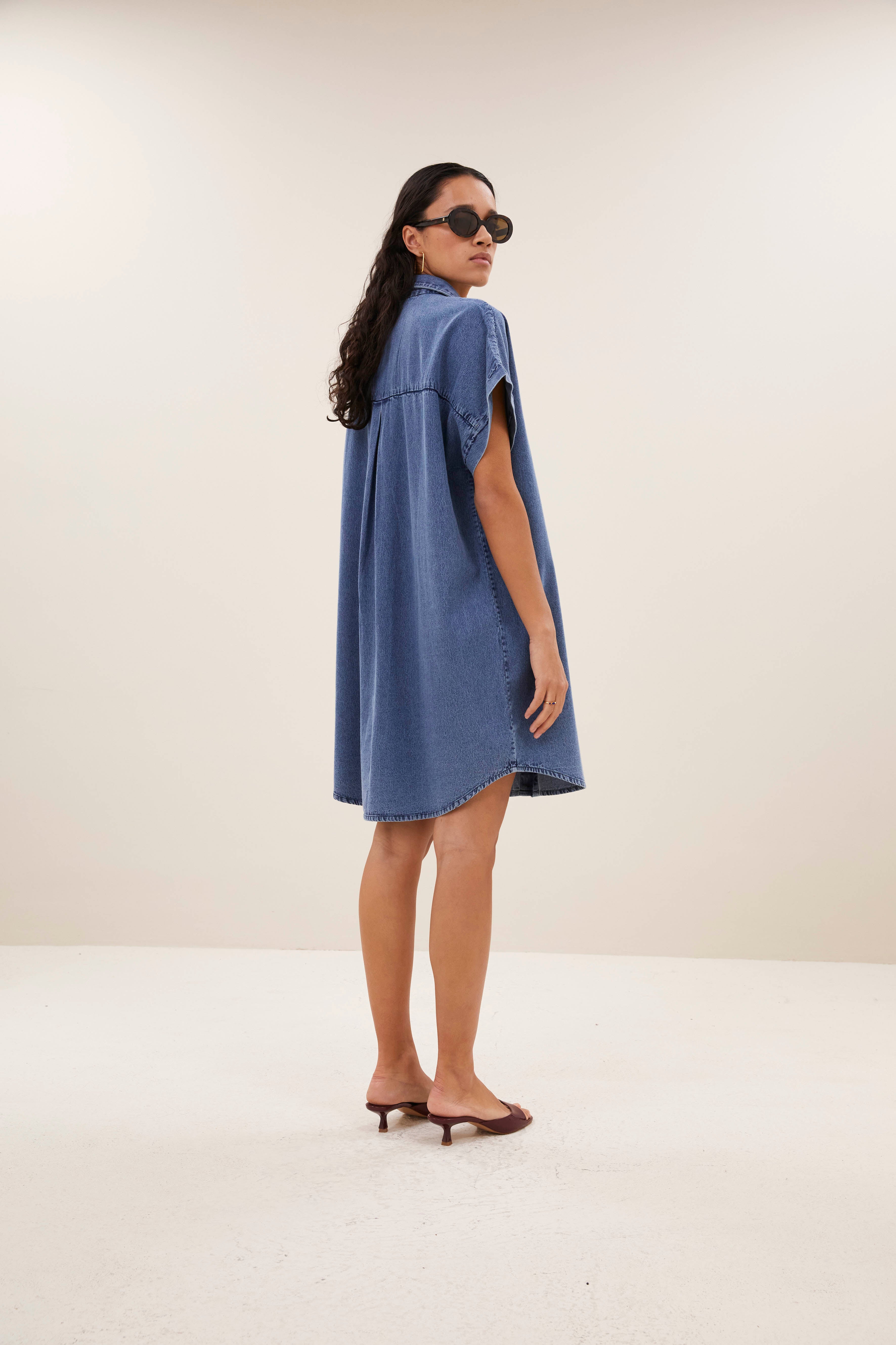 hella-denim-dress-medium-denim-knoopsluiting-gemaakt door weefspecialist-opstaande kraag-by-bar-vooraanzicht