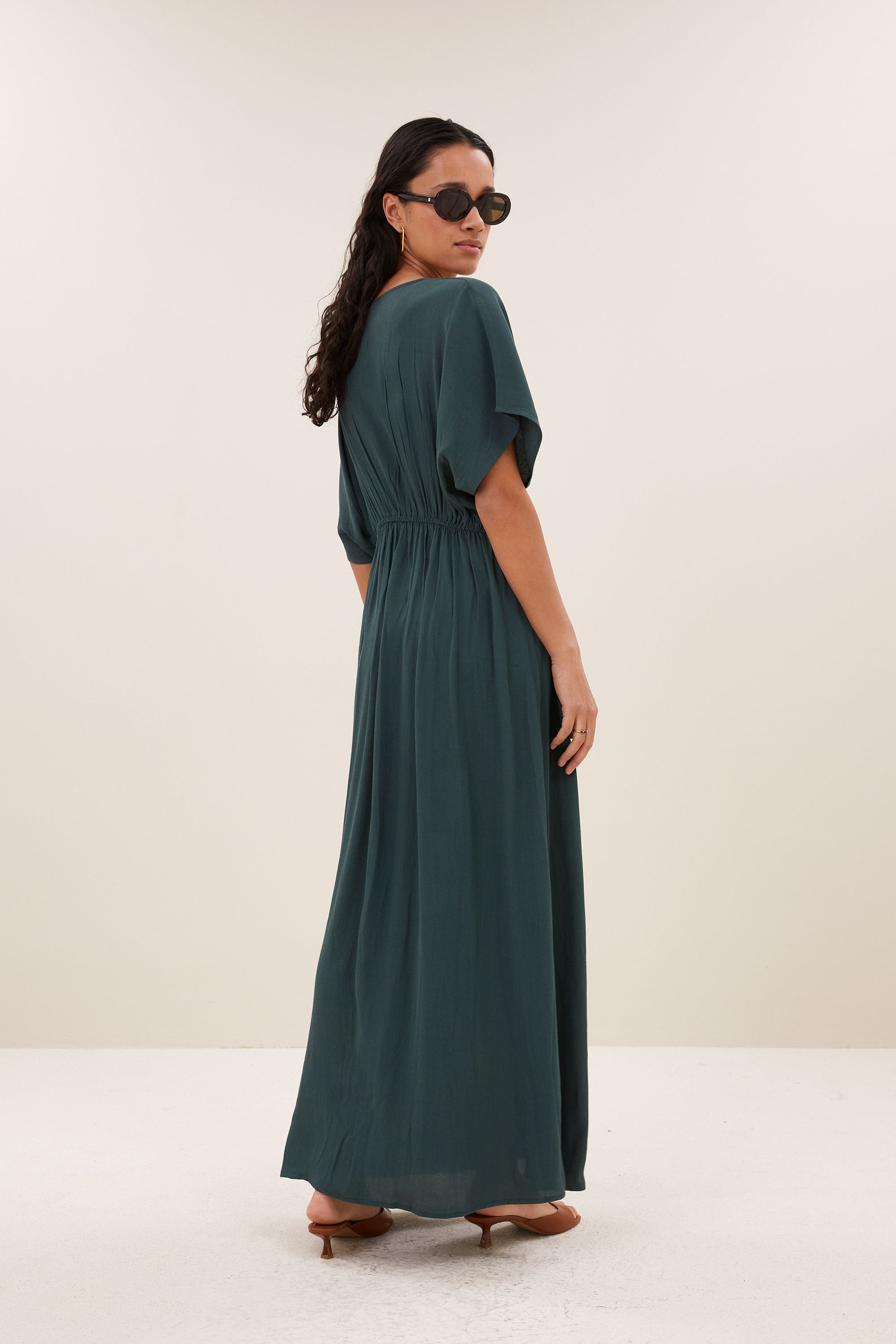 long-twill-dress-dried-basil-1-vleermuis mouw-geplooide details-v-halslijn-by-bar-achteraanzicht